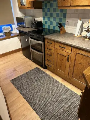 a kitchen with a stove and a counter top at Engellie Cottage in Perranporth