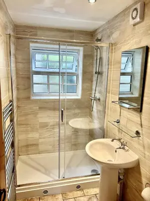 a bathroom with a shower and a sink at Engellie Cottage in Perranporth