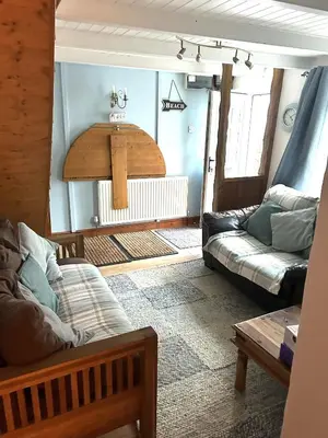 a living room with a couch and a table at Engellie Cottage in Perranporth