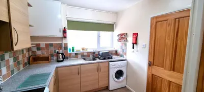 a kitchen with a sink and a washing machine at Sand Bay, Perranporth in Perranporth