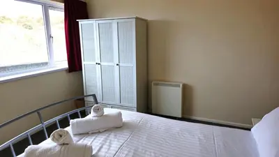 a bedroom with a bed with towels on it at Sand Bay, Perranporth in Perranporth