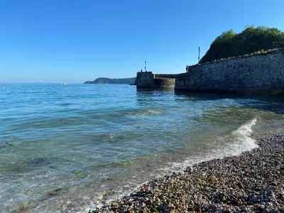 a rocky shoreline with a stone wall and the water at Mona's Cottage - Private Parking, Sea Views, Garden & Close To Harbour & Beach in Charlestown