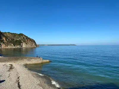 a person standing on the shore of a body of water at Mona's Cottage - Private Parking, Sea Views, Garden & Close To Harbour & Beach in Charlestown