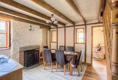a dining room with a table and chairs and a fireplace at Mona's Cottage - Private Parking, Sea Views, Garden & Close To Harbour & Beach in Charlestown