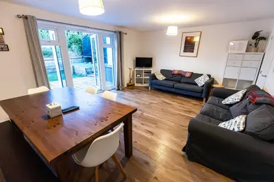a living room with a wooden table and a couch at Piran View in Perranporth