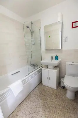 a bathroom with a toilet and a sink and a shower at Piran View in Perranporth