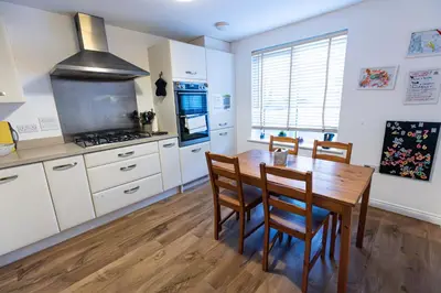 a kitchen with a table and chairs and a stove at Piran View in Perranporth