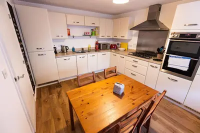 a kitchen with a wooden table and a stove at Piran View in Perranporth