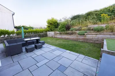 a patio with a table and chairs in a yard at Piran View in Perranporth