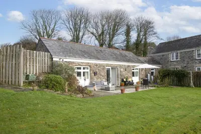 an old stone house with a garden and a yard at Samson Cottage in Saint Mawgan