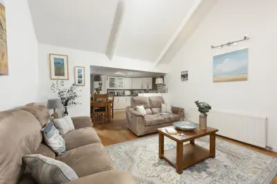 a living room with a couch and a table at Samson Cottage in Saint Mawgan