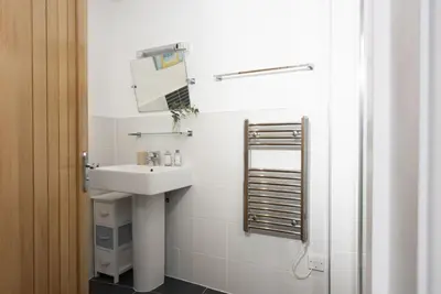 a bathroom with a sink and a mirror at Samson Cottage in Saint Mawgan