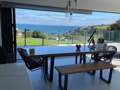 a dining room table with a view of the ocean at Mayflower in St Austell