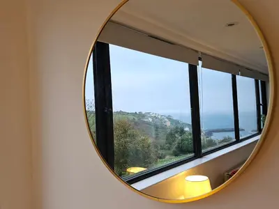 a mirror in a room with a window at Mayflower in St Austell