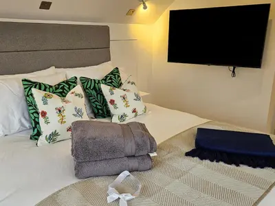 a bedroom with a bed with a flat screen tv at Mayflower in St Austell