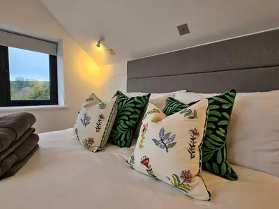 a bed with green and white pillows on it at Mayflower in St Austell