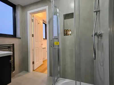 a bathroom with a shower with a glass door at Mayflower in St Austell