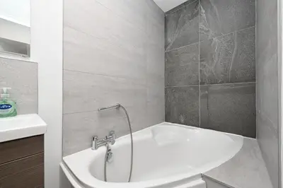 a bathroom with a tub and a sink at Luxury 3-Bed house, Beach 300m, Sleeps 6, Parking in Newquay