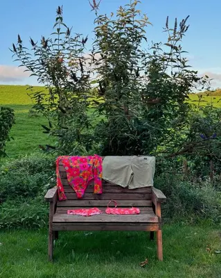 a blanket on top of a wooden bench at Elderflower Hut in Port Isaac