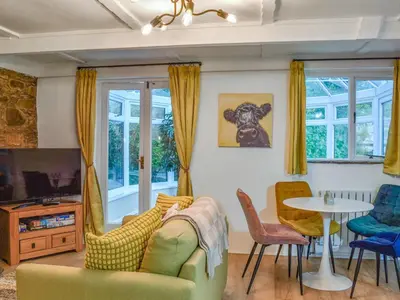 a living room with a couch and a table at Byre Cottage in Fowey