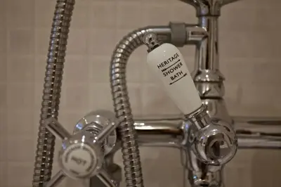 a bottle of toothpaste is attached to a faucet at Grade II Listed Cottage Gorran Haven Sea Views in Gorran Haven