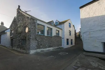 an old stone building on the side of a street at Grade II Listed Cottage Gorran Haven Sea Views in Gorran Haven