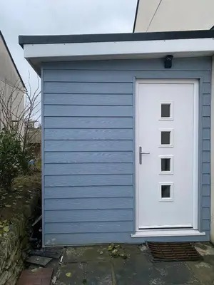 a blue garage with a white door on it at Seaside Cabin Perranporth in Perranporth