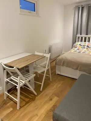 a room with a table and chairs and a bed at Seaside Cabin Perranporth in Perranporth