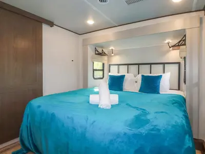 a bedroom with a large bed with blue sheets at Tickeydoo, Tor Down Quarry in Bodmin
