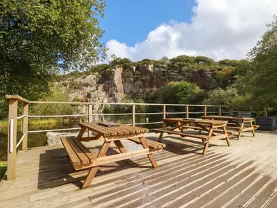 a group of picnic tables on a wooden deck at Tickeydoo, Tor Down Quarry in Bodmin
