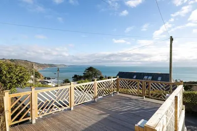 a wooden balcony with a view of the ocean at Luxury Cornish Seaview Bungalow in Looe
