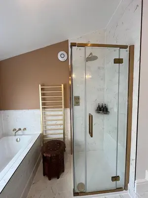 a bathroom with a shower and a tub at Luxury Cornish Seaview Bungalow in Looe