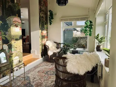 a living room with two chairs and a window at Luxury Cornish Seaview Bungalow in Looe