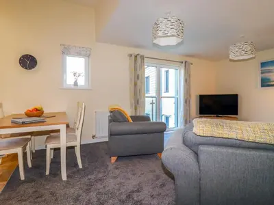 a living room with a couch and a table at Freesia in Truro