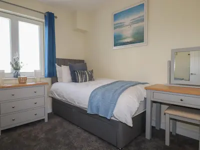 a bedroom with a bed and a dresser and a television at Freesia in Truro