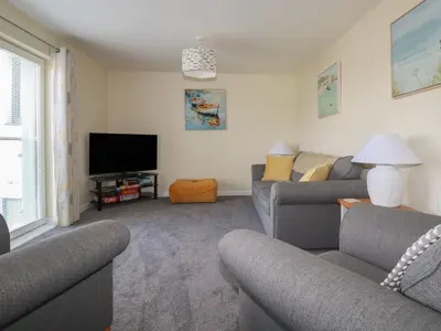 a living room with two couches and a flat screen tv at Freesia in Truro