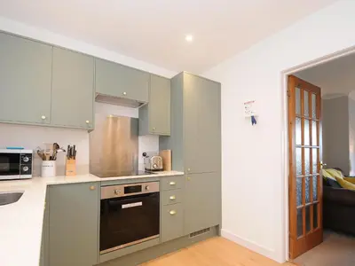 a kitchen with green cabinets and a stove top oven at Sea Spray in Port Isaac