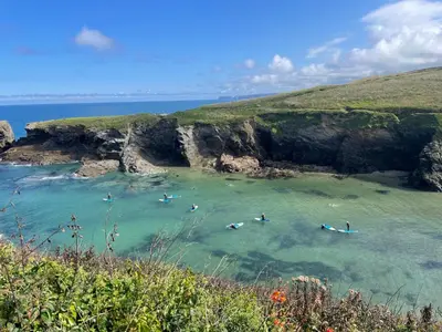 a group of people in the water at a beach at Sea Spray in Port Isaac