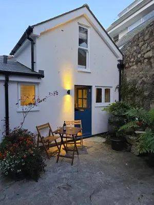 a table and chairs in front of a white house at 4 Tre Pol Pen, and the Wash Kitchen in St Ives