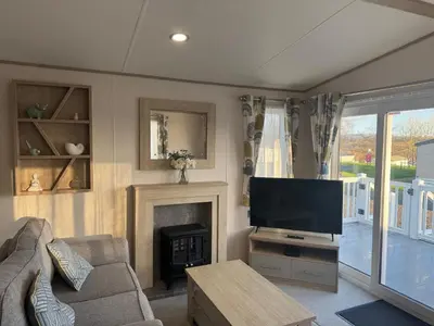 a living room with a television and a fireplace at Wallows Lodge with private hot tub in St Austell