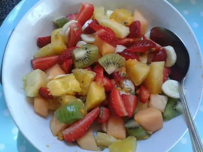 a bowl of fruit salad with a spoon in it at Wild Air Guest House in Mevagissey