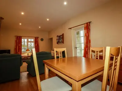 a dining room with a wooden table and chairs at The Coach House in Camelford