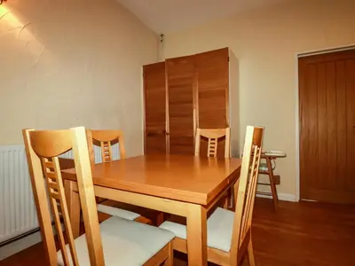 a wooden table and chairs in a room at The Coach House in Camelford