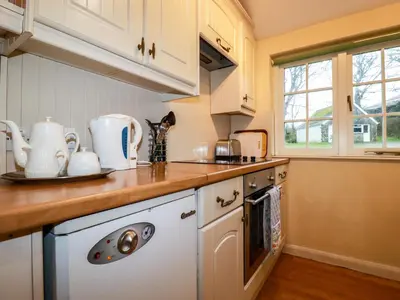 a kitchen with white cabinets and a counter top at The Coach House in Camelford