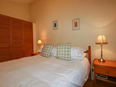 a bedroom with a white bed with two pillows at The Smithy in Camelford