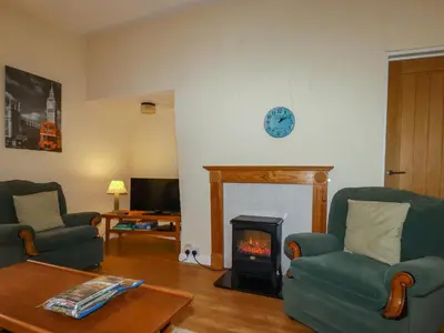 a living room with two chairs and a fireplace at The Smithy in Camelford