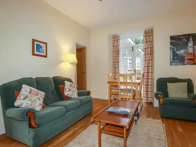 a living room with a green couch and a table at The Smithy in Camelford