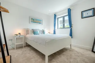 a white bedroom with a bed and a window at 4 Bed in Porthleven oc-ch30536 in Porthleven