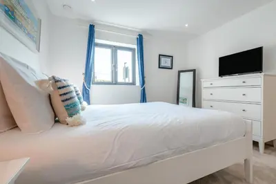 a white bedroom with a bed and a tv at 4 Bed in Porthleven oc-ch30536 in Porthleven