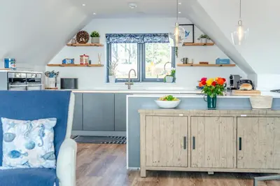 a kitchen with a counter and a blue chair at 4 Bed in Porthleven oc-ch30536 in Porthleven